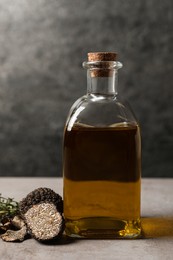 Photo of Fresh truffles and oil on light grey table