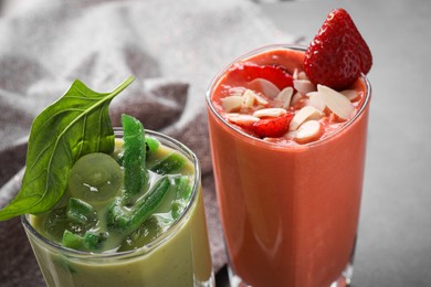 Different delicious smoothies on grey table, closeup