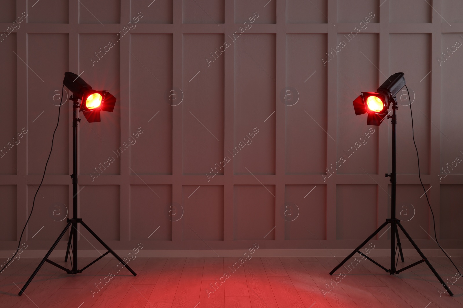 Photo of Bright red spotlights near wall indoors, space for text