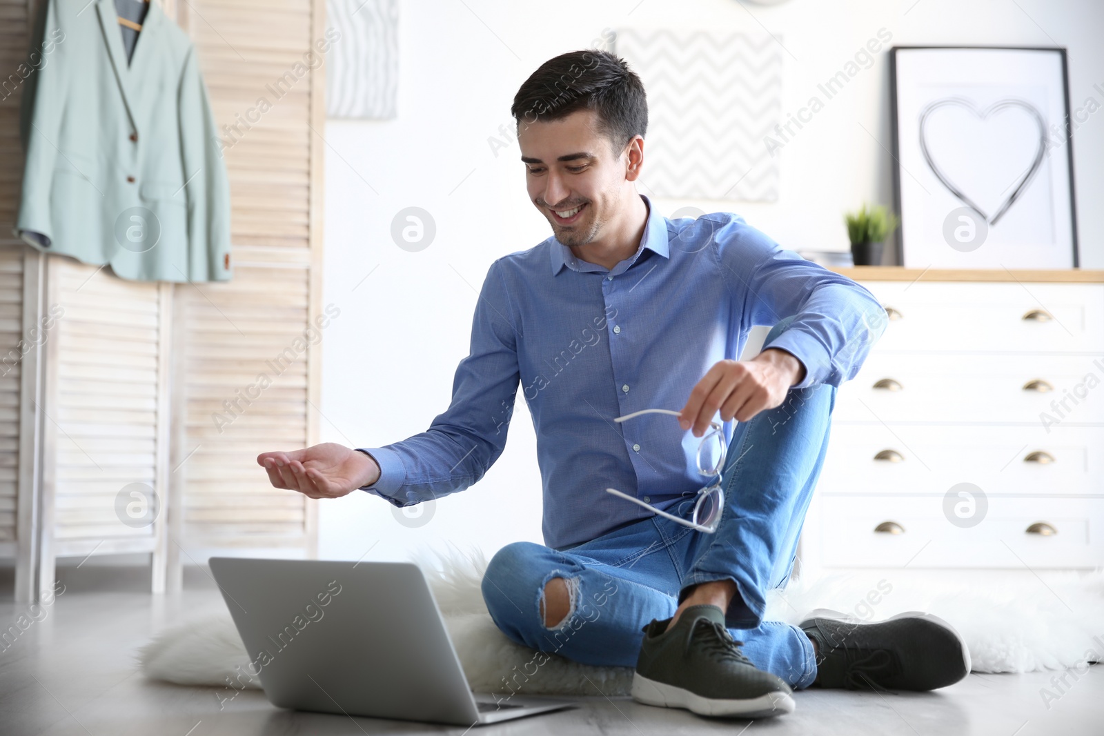 Photo of Young blogger with laptop on floor at home