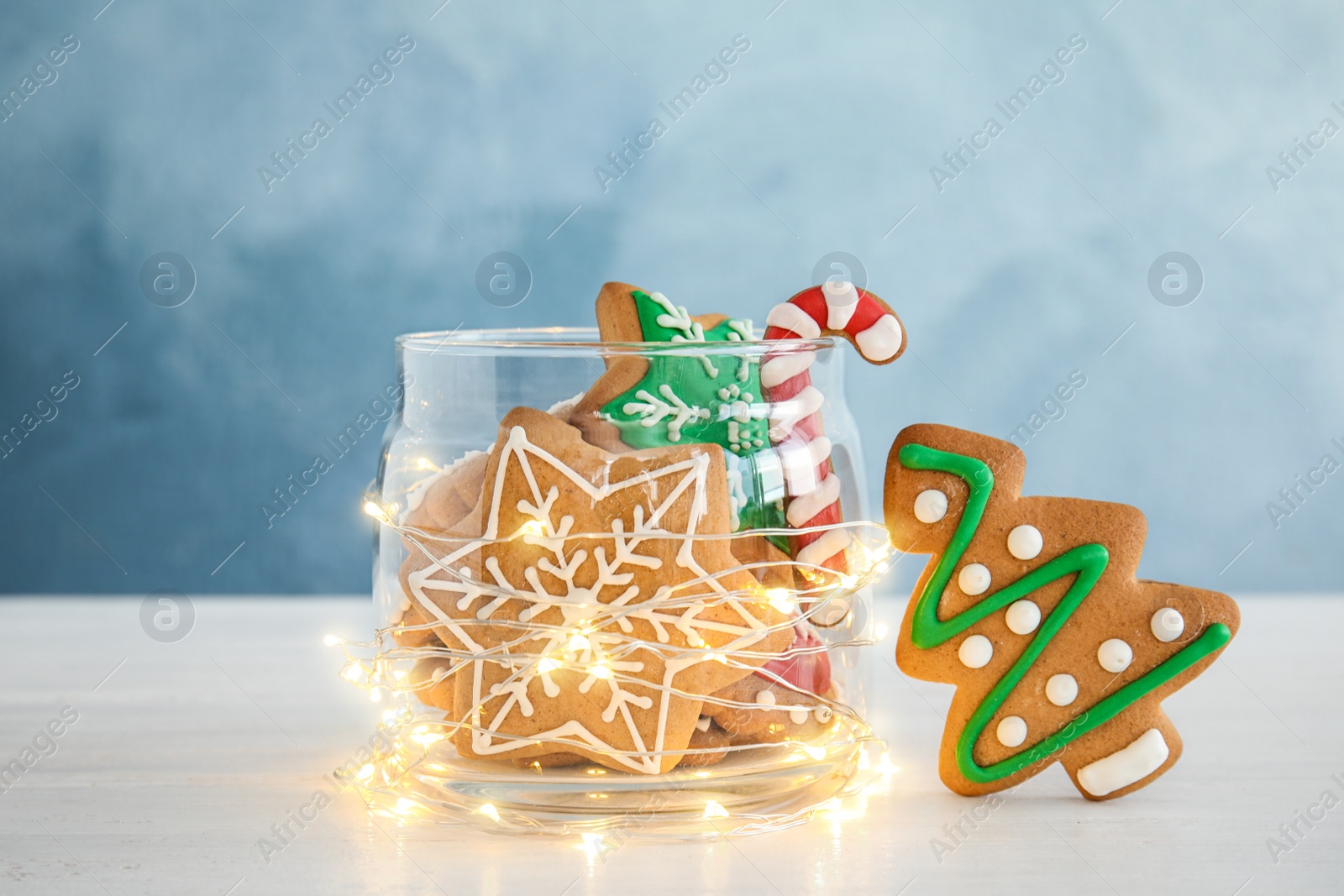 Photo of Glass jar with tasty homemade Christmas cookies on table