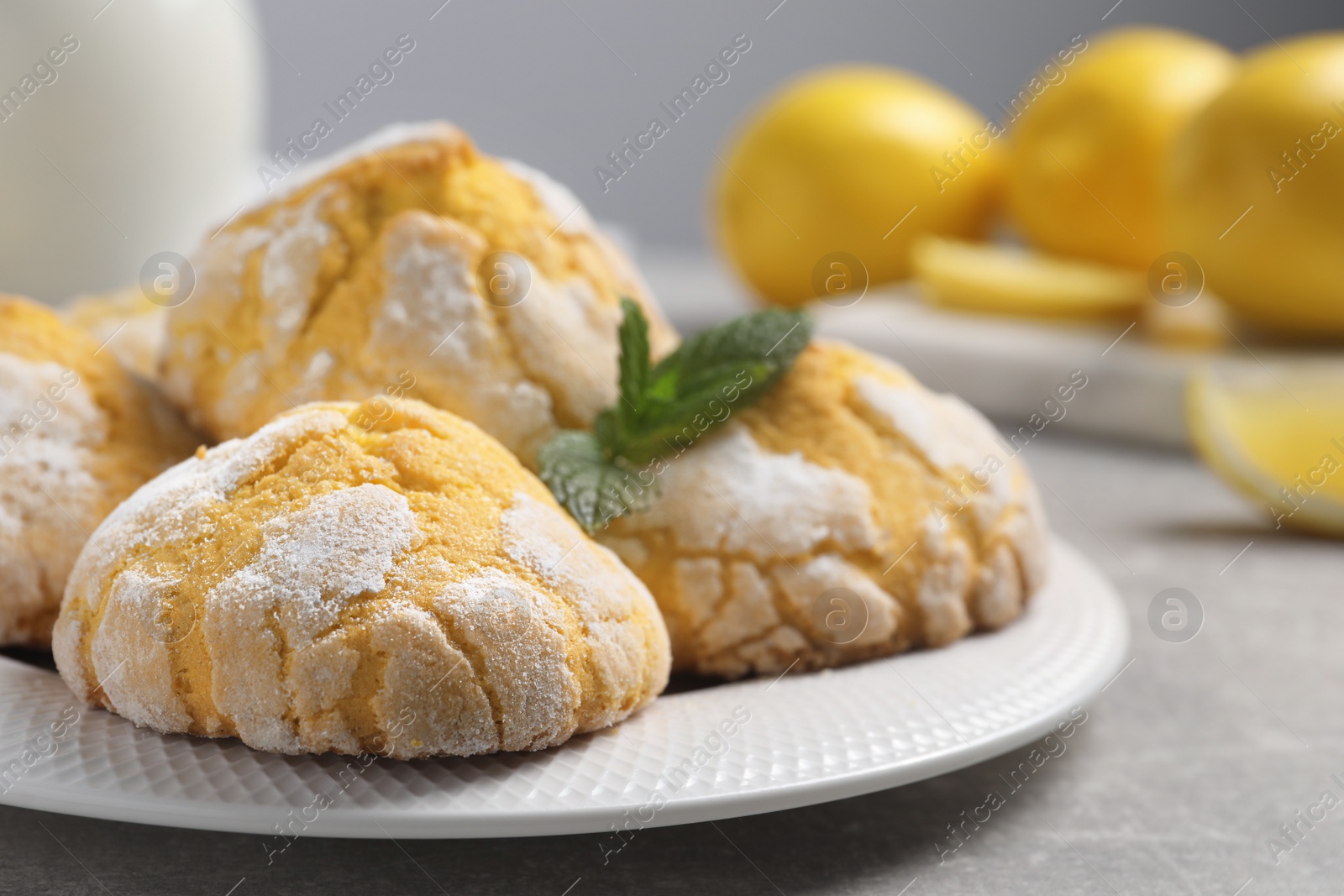 Photo of Plate with delicious lemon cookies and mint on grey table, closeup