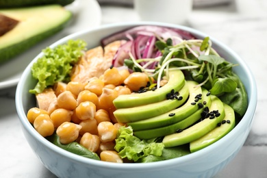 Photo of Delicious avocado salad with chickpea on white table, closeup