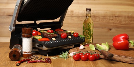 Photo of Electric grill with different products and knife on wooden table