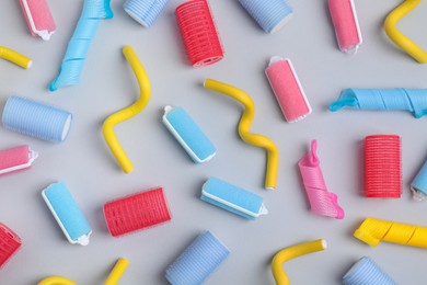 Photo of Different hair curlers on light grey background, flat lay. Styling tool