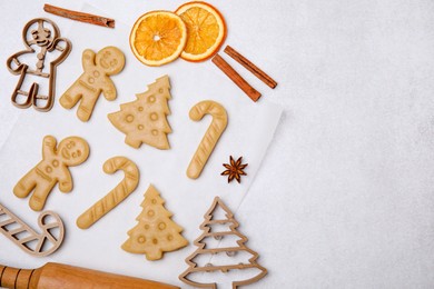 Photo of Christmas treat. Flat lay composition with cookie cutters and dough on light table, space for text