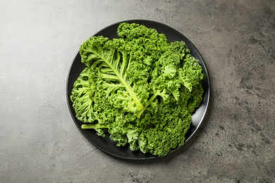 Photo of Fresh kale leaves on grey table, top view