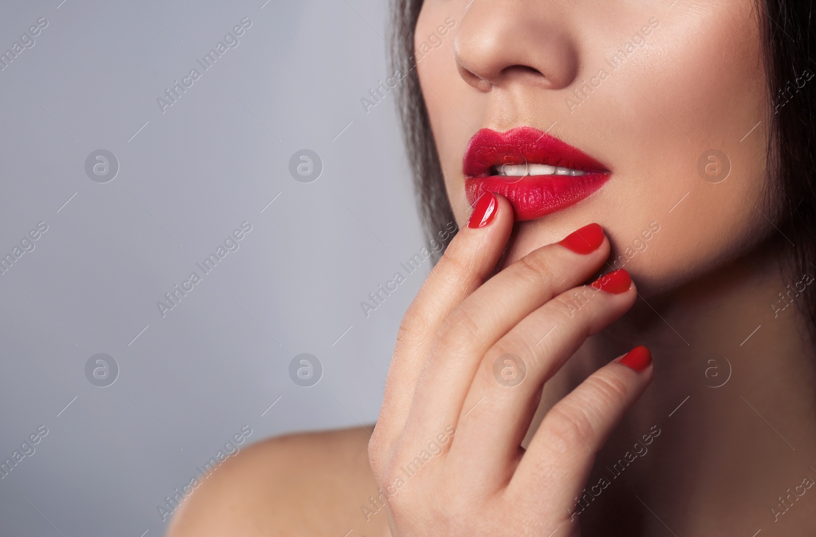 Photo of Beautiful woman with stylish nail polish on grey background, closeup. Space for text