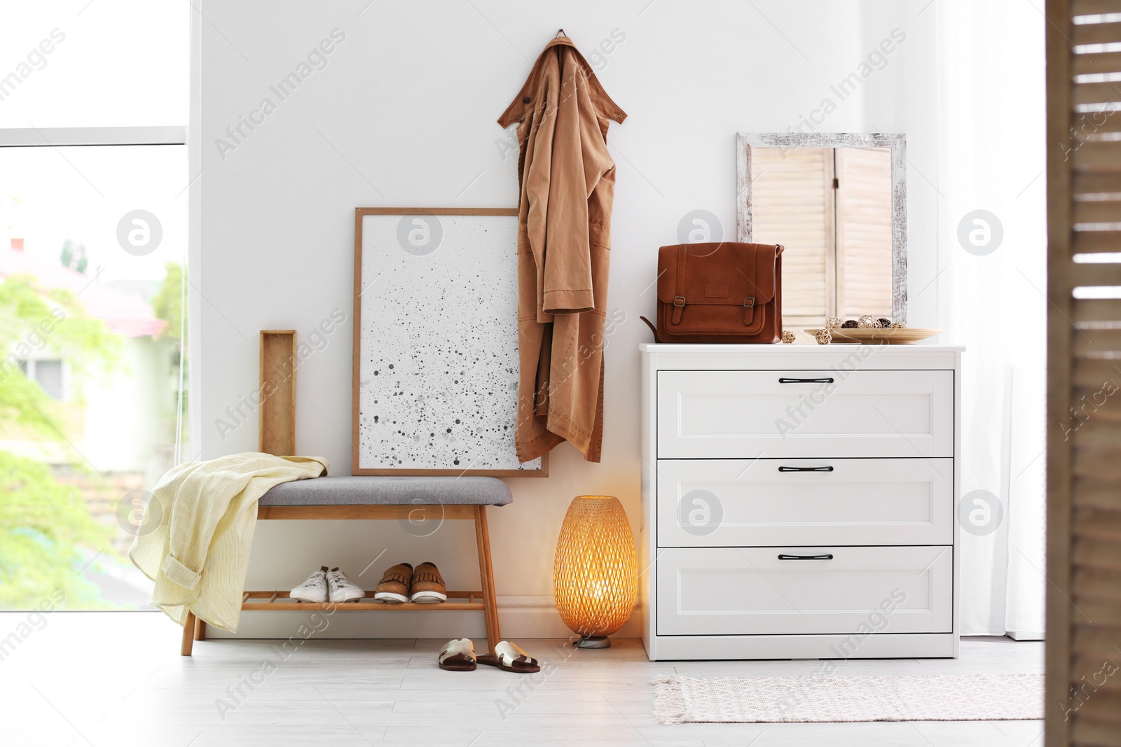 Photo of Modern hallway interior with shoe storage bench and chest of drawers. Space for text