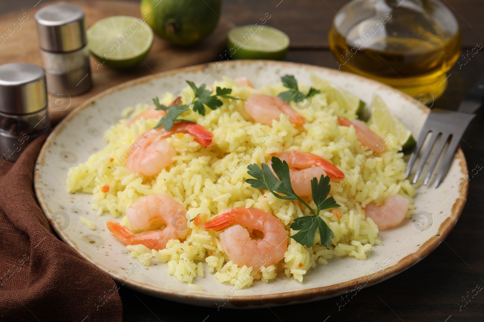 Photo of Delicious risotto with shrimps and parsley on wooden table, closeup