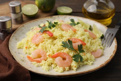 Delicious risotto with shrimps and parsley on wooden table, closeup