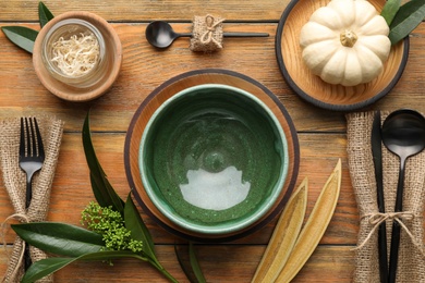 Autumn table setting with pumpkin and decor on wooden background, flat lay