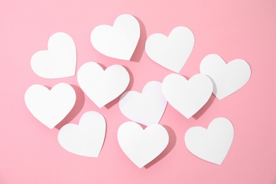 Small paper hearts on color background, top view