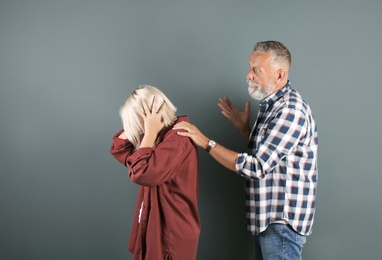 Photo of Mature couple having argument on color background. Relationship problems