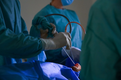 Photo of Professional doctors performing 
operation in surgery room, closeup