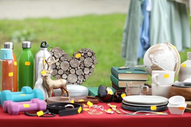 Photo of Different items on table outdoors. Garage sale