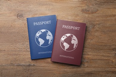 Different international passports on wooden table, flat lay