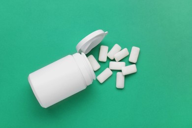 Photo of Jar with chewing gums on green background, flat lay