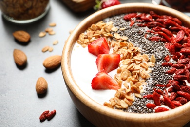Photo of Smoothie bowl with goji berries on grey table, closeup