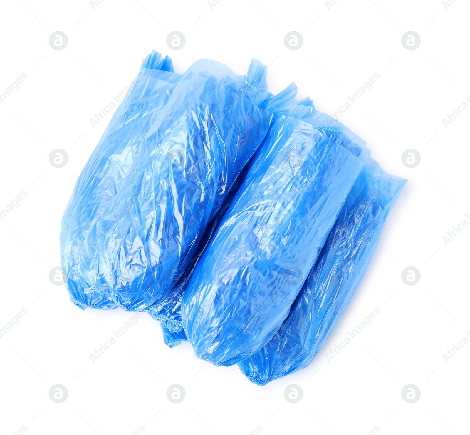 Photo of Many rolled blue shoe covers isolated on white, top view