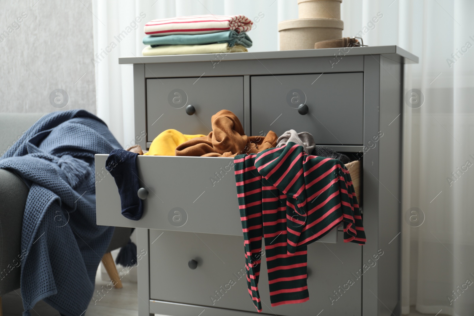 Photo of Cluttered room. Clothes in mess all around place