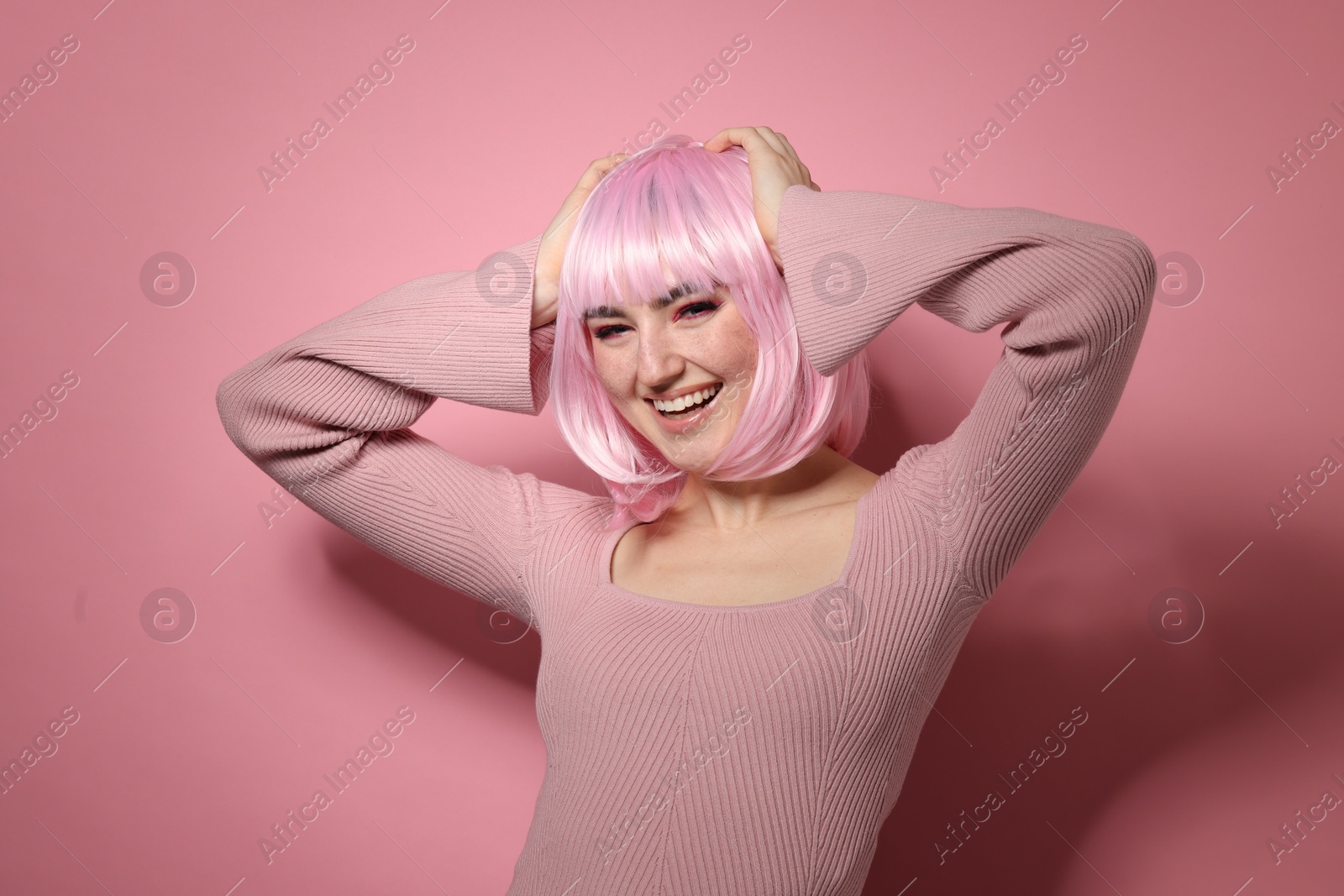 Photo of Happy woman with bright makeup and fake freckles on pink background