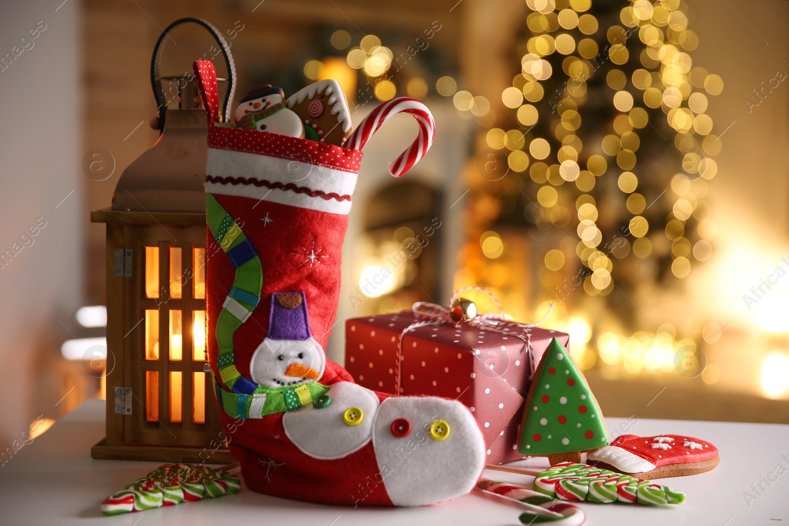 Photo of Stocking, sweets, gift box and lantern on table. Saint Nicholas Day tradition