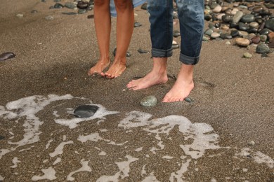 Photo of Young couple on sandy beach near sea, closeup