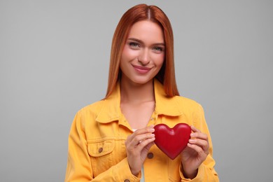 Photo of Beautiful woman with red heart on grey background