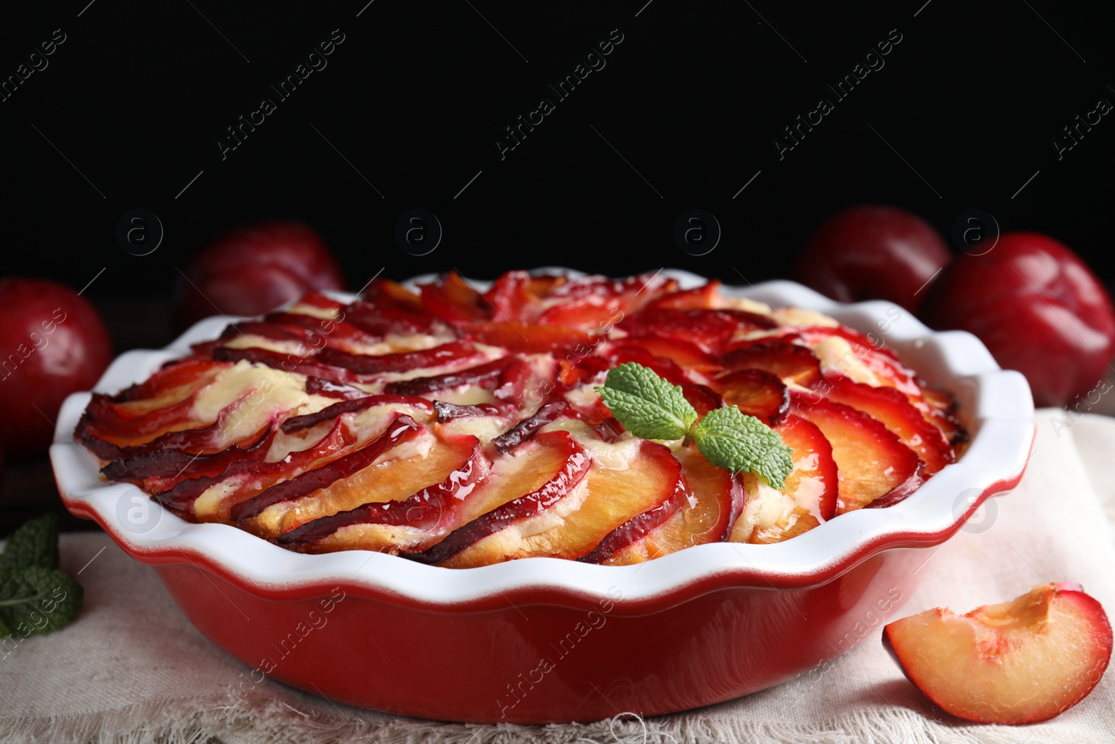 Photo of Delicious cake with plums in baking dish, closeup