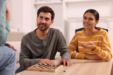 Family talking while playing checkers at home