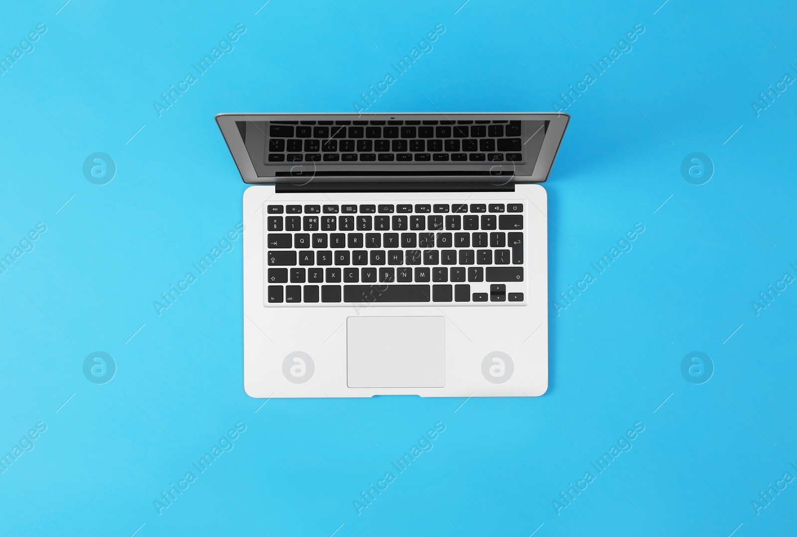 Photo of Modern laptop on blue background, top view