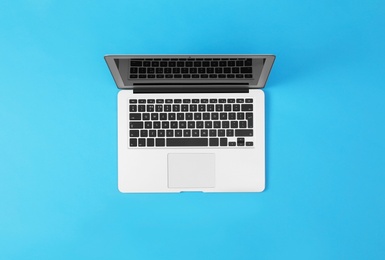 Photo of Modern laptop on blue background, top view