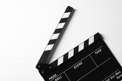 Photo of Clapperboard on white wooden table, top view. Space for text