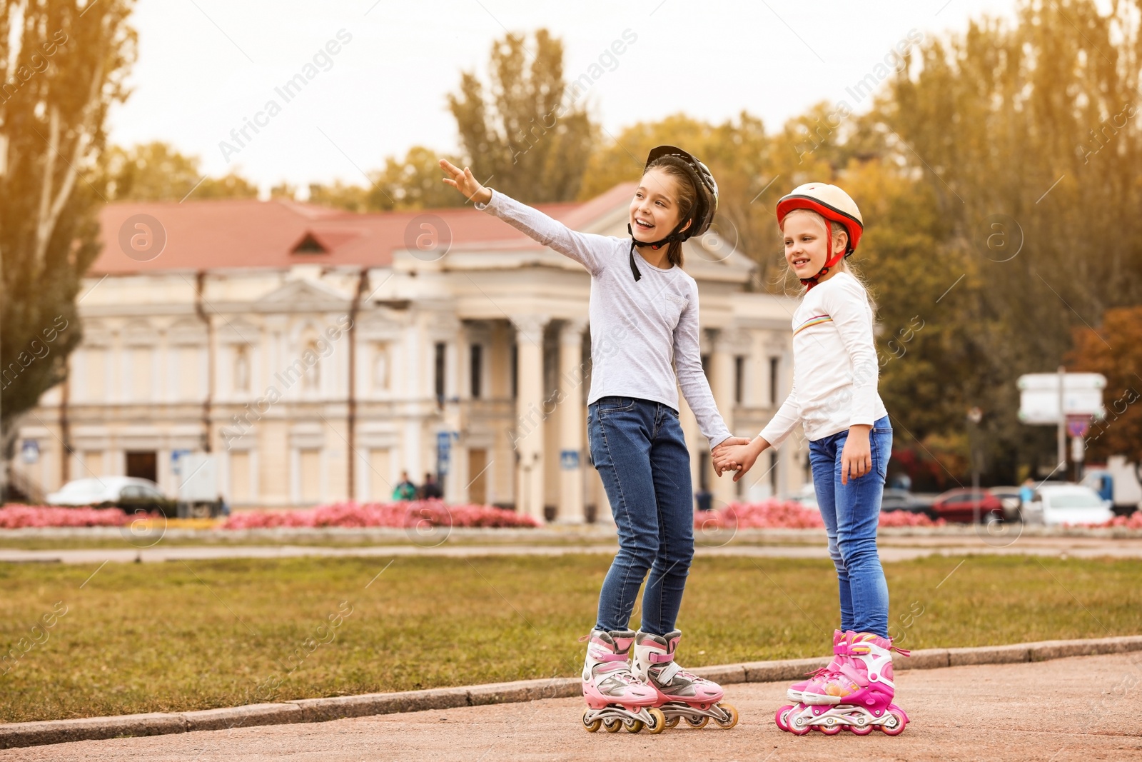 Photo of Happy children wearing roller skates on city street