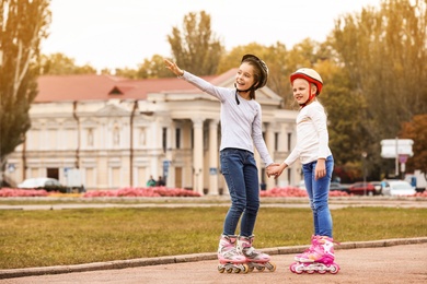 Happy children wearing roller skates on city street