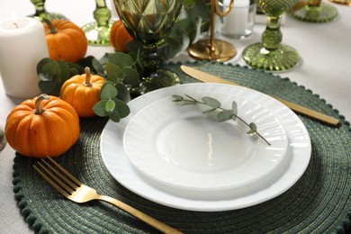 Photo of Beautiful autumn table setting. Plates, cutlery, glasses, pumpkins and floral decor