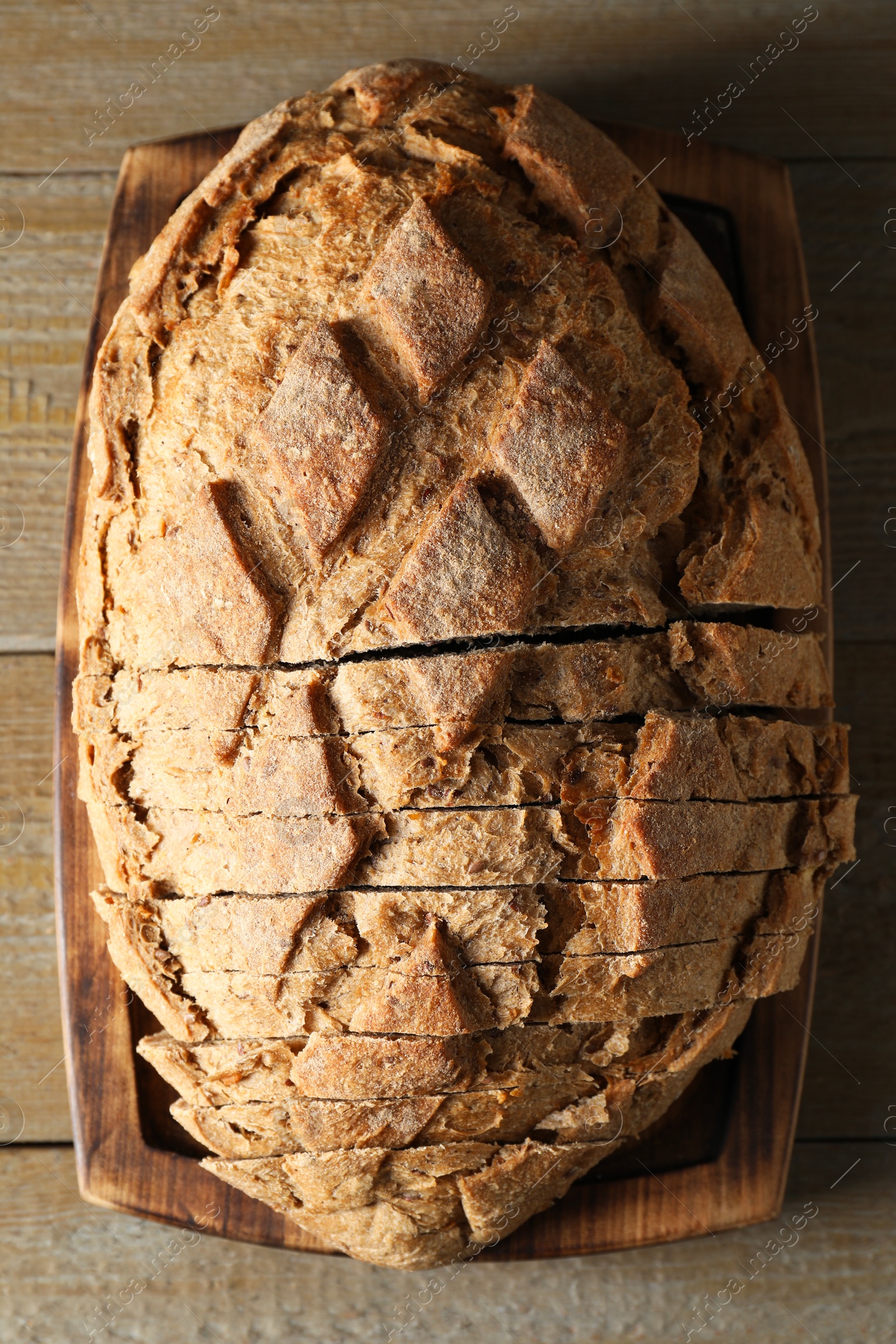 Photo of Freshly baked cut sourdough bread on wooden table