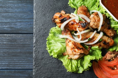 Slate plate with tasty shish kebab and sauce, top view