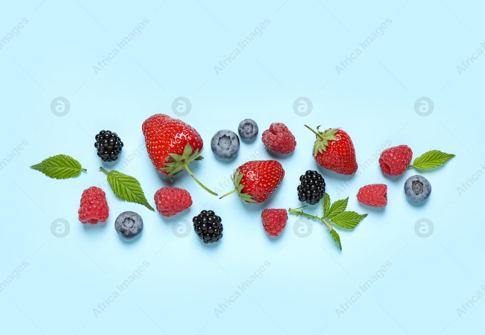 Photo of Different fresh berries on light blue background, flat lay