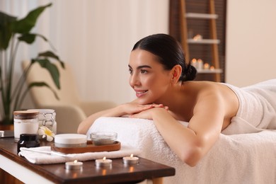 Photo of Young woman resting on massage couch in spa salon