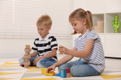 Little children playing with building blocks indoors. Wooden toys