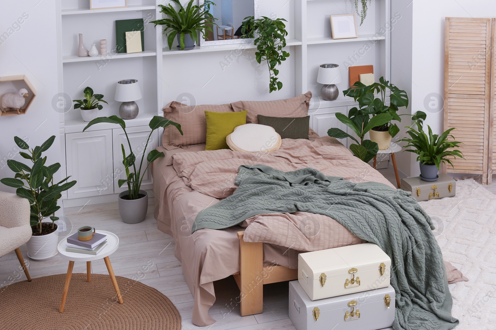 Photo of Stylish bedroom with comfortable bed and different houseplants. Interior design