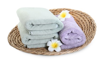 Different folded soft towels and plumeria flowers isolated on white