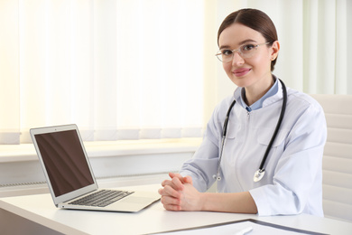 Photo of Portrait of young female doctor in white coat at workplace