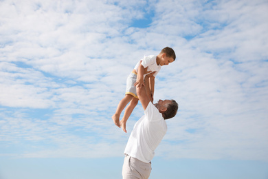 Photo of Grandfather playing with cute little boy outdoors