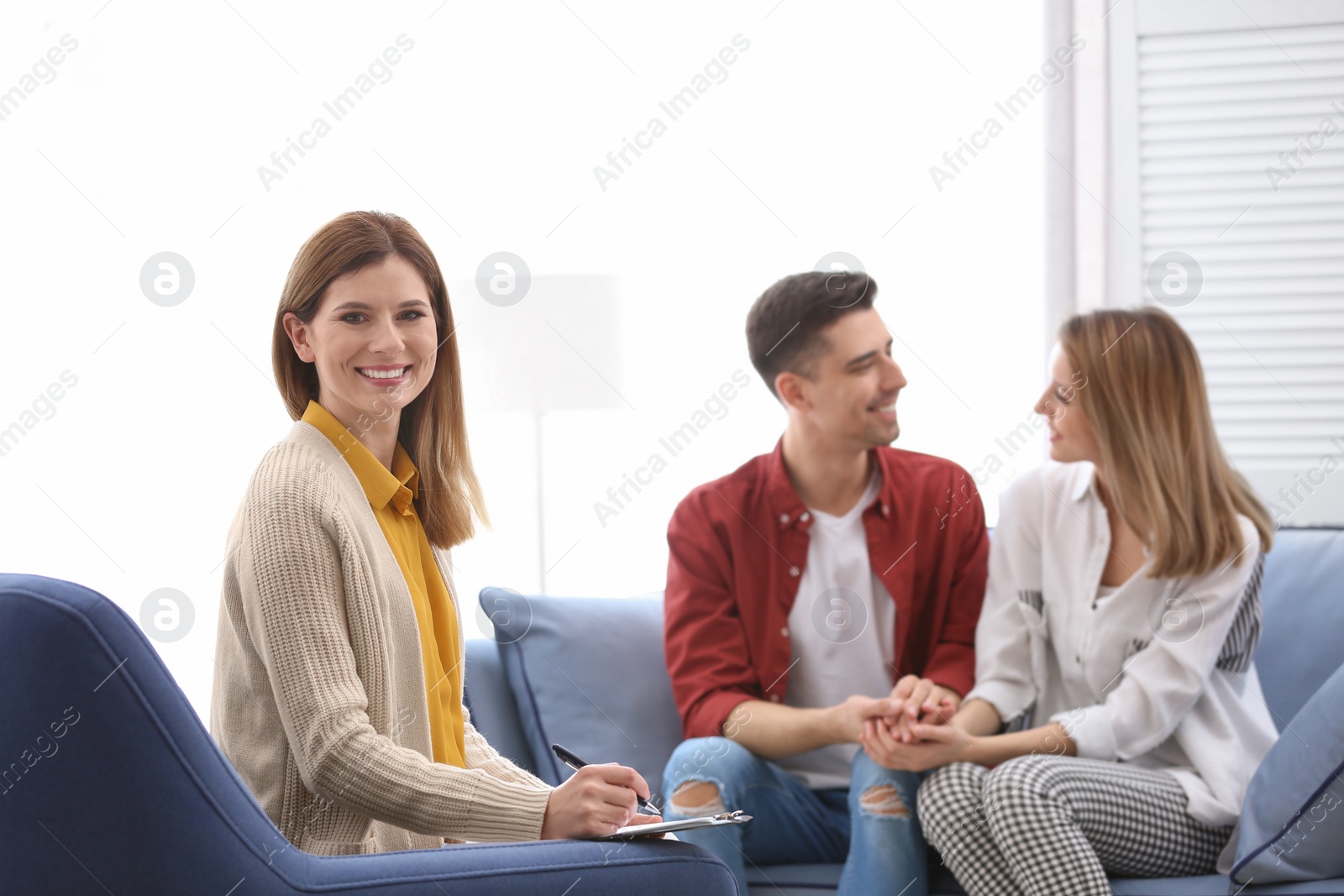 Photo of Young happy couple after therapy session with family psychologist indoors