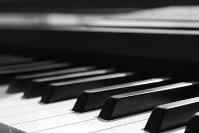 Photo of Modern piano with black and white keys indoors, closeup