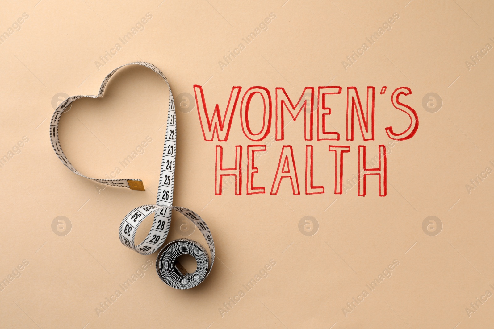 Photo of Measuring tape near words Women's Health on beige background, top view