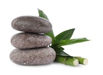Photo of Stack of spa stones and bamboo on white background